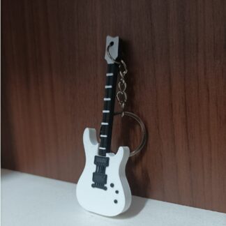 White colored Guitar keychain kept on a shelf